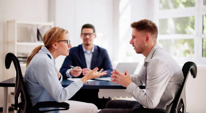 Couple arguing while meeting with Family lawyer